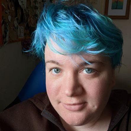 A photograph of Piper, a nonbinary person with blue hair